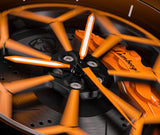 Close-up of an orange and black car wheel with 'KTM' branding on a dark background